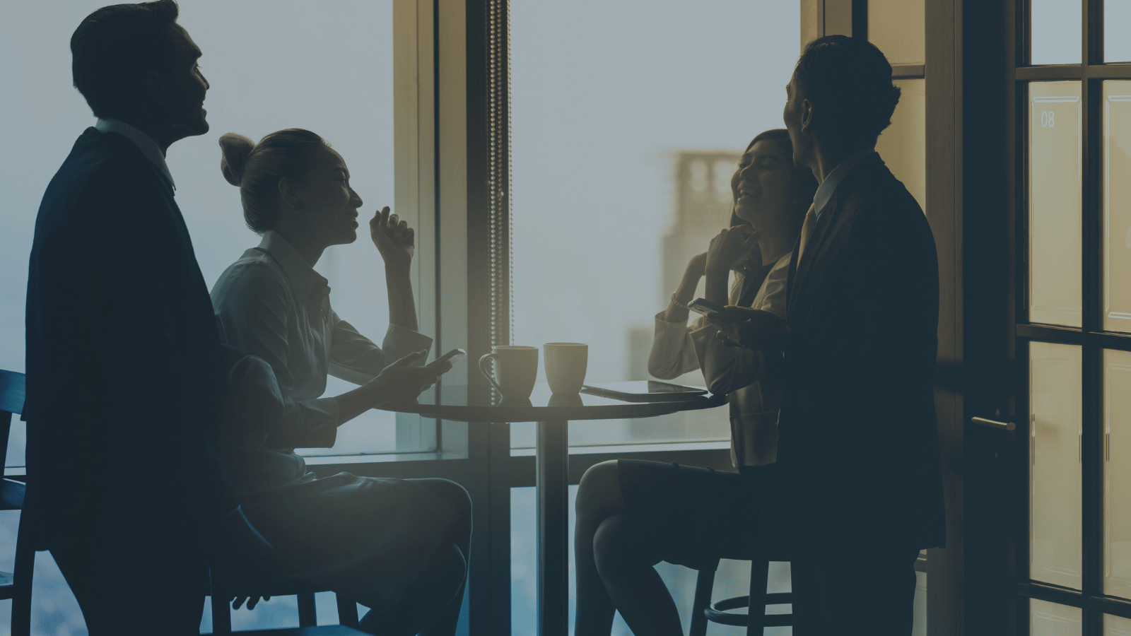 Colleague stand around a table enjoying a coffee